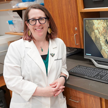 Kate Lesciotto poses with computer monitor in lab