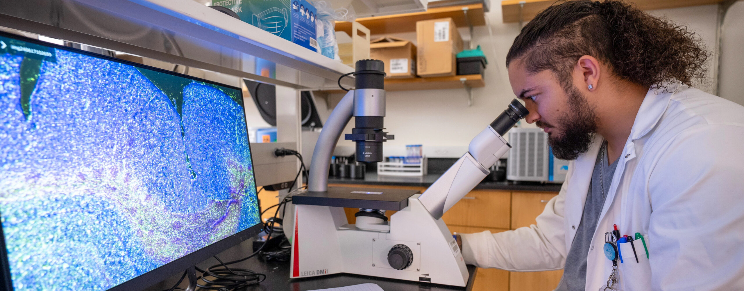 student looking through microscope in a lab