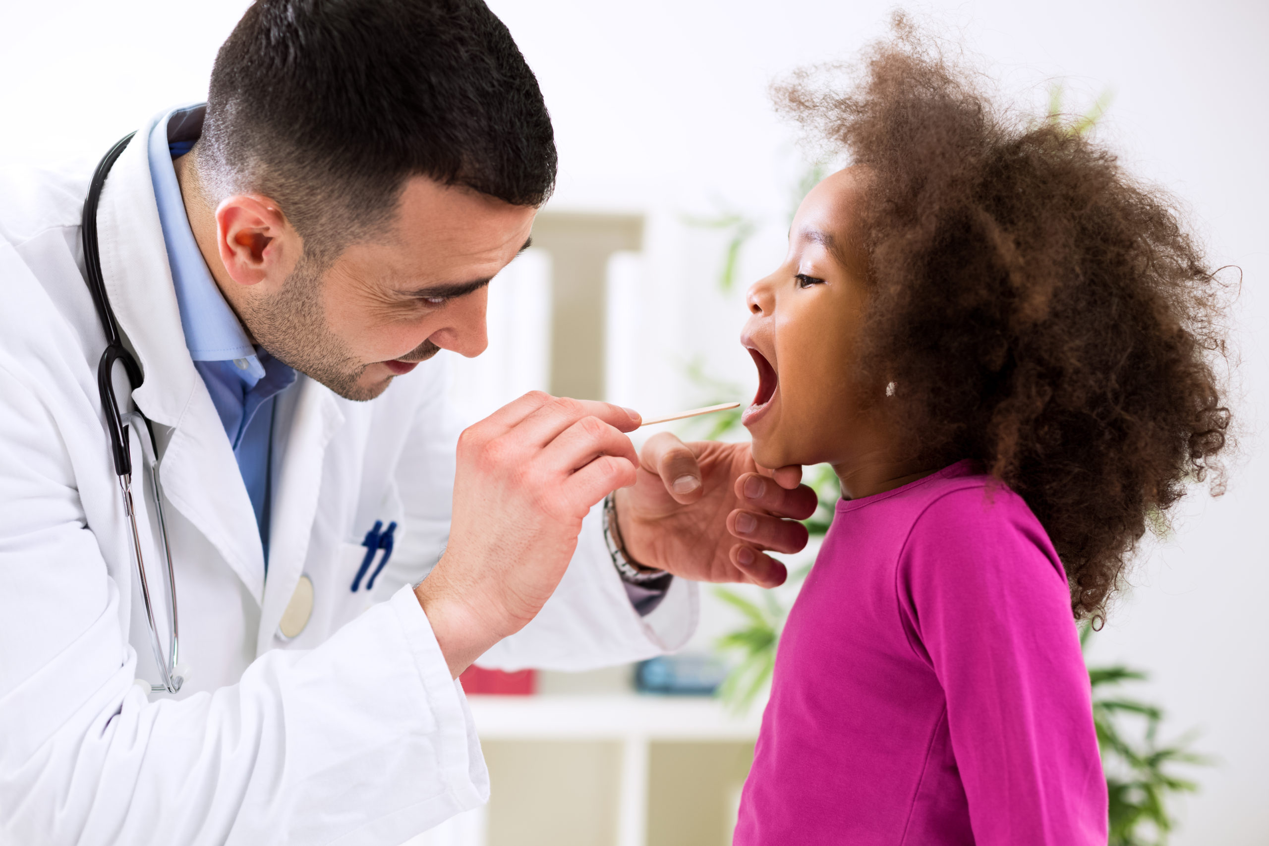 Doctor examining a child's throat