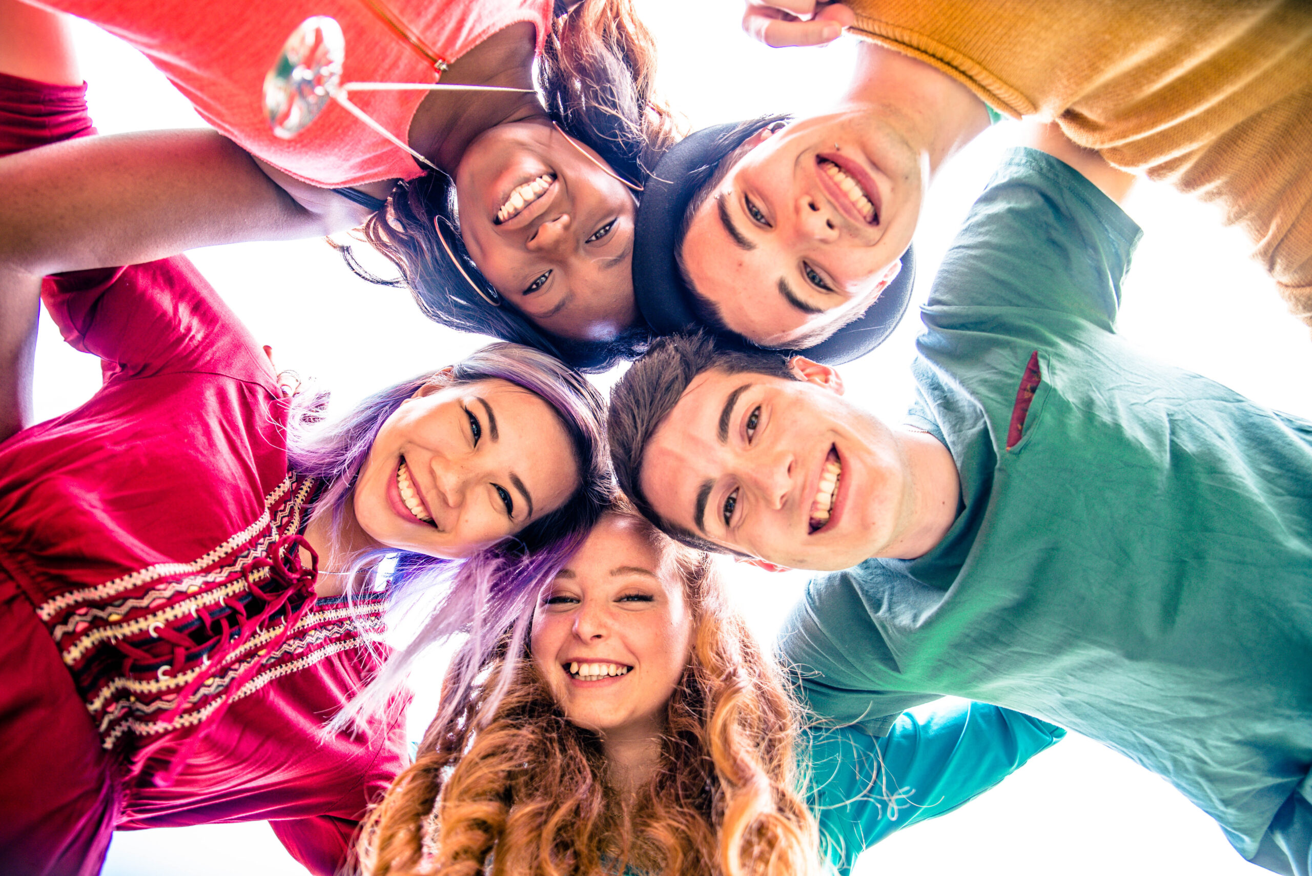 Teenagers in a circle looking down at camera