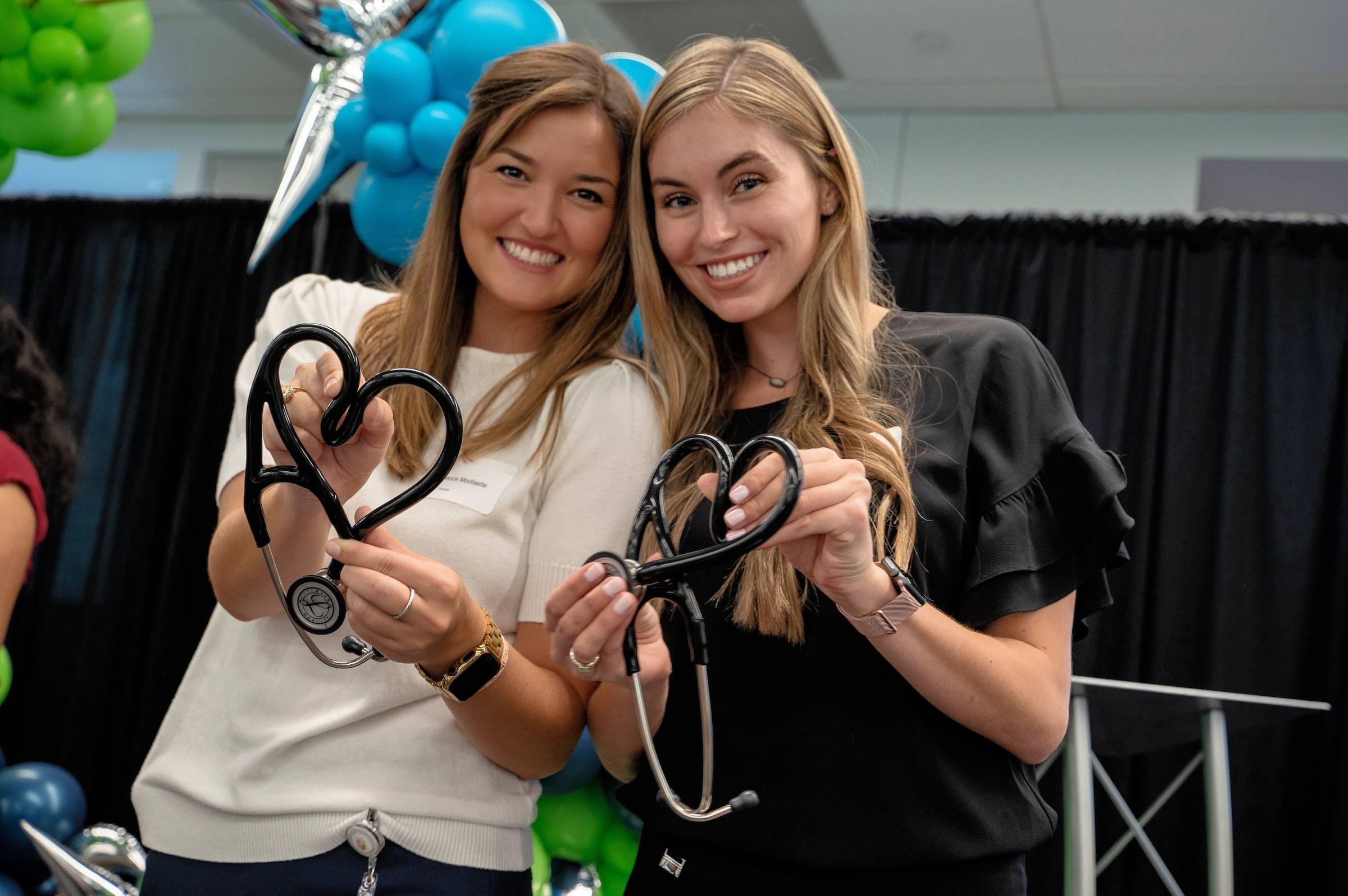 Three students posing for a photo with their new stethoscopes