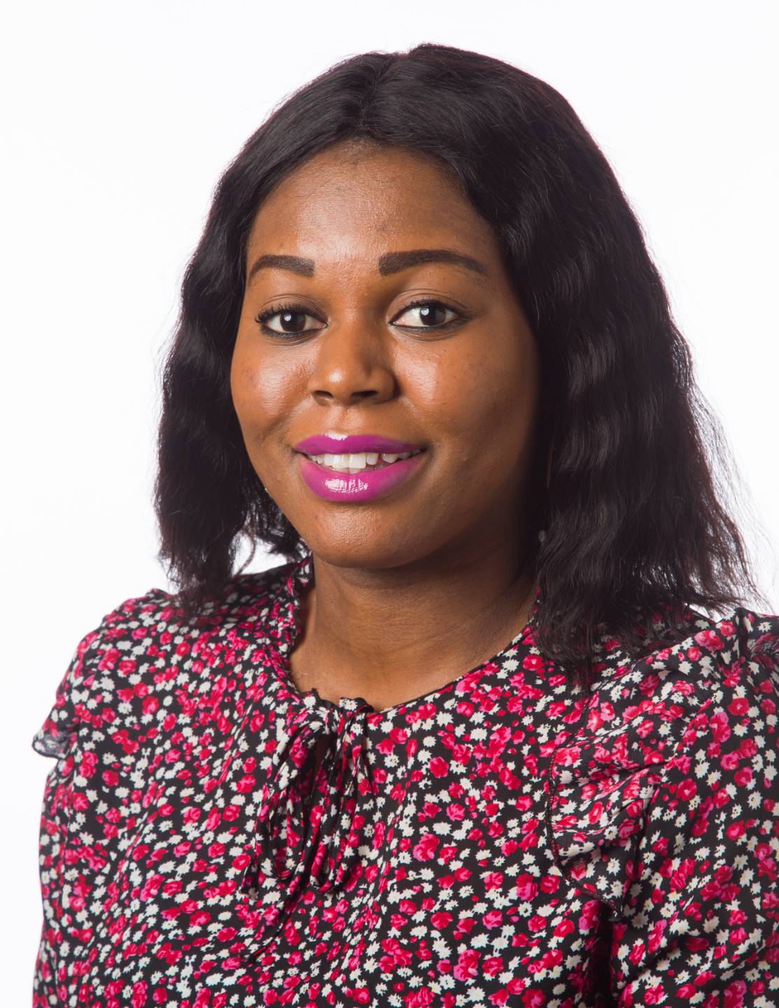 Aderonke Dosumu headshot wearing a red floral blouse with a white background
