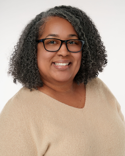 Kenya Samuels headshot wearing a tan sweater