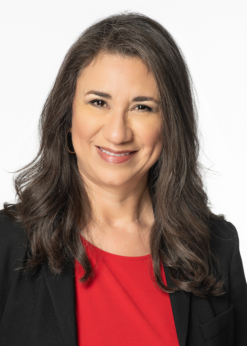 Conchita Adrijeski headshot wearing a black jacket with a red shirt underneath
