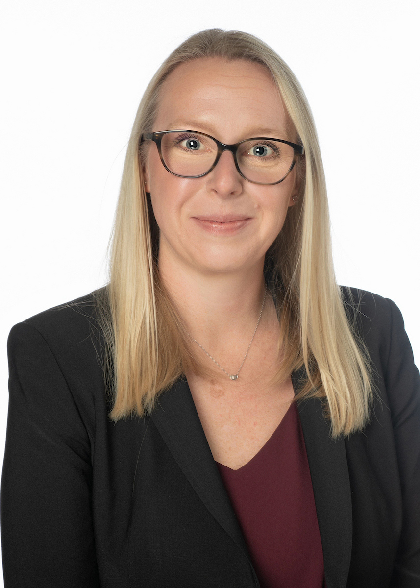 Megan Wesling headshot wearing a black blazer with a maroon top underneath
